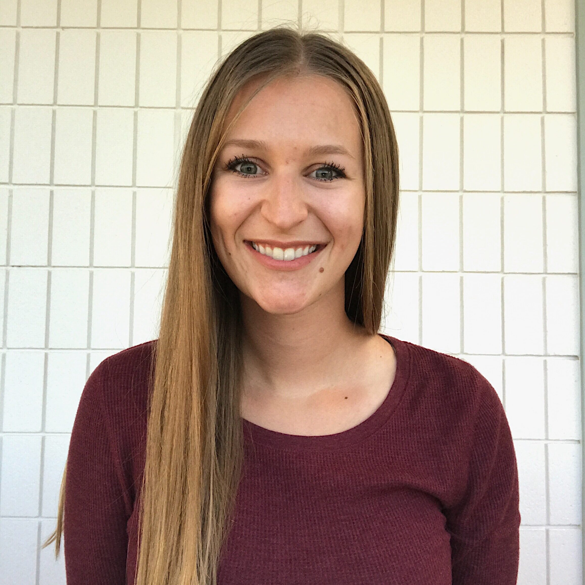 A woman with long hair smiles for the camera.